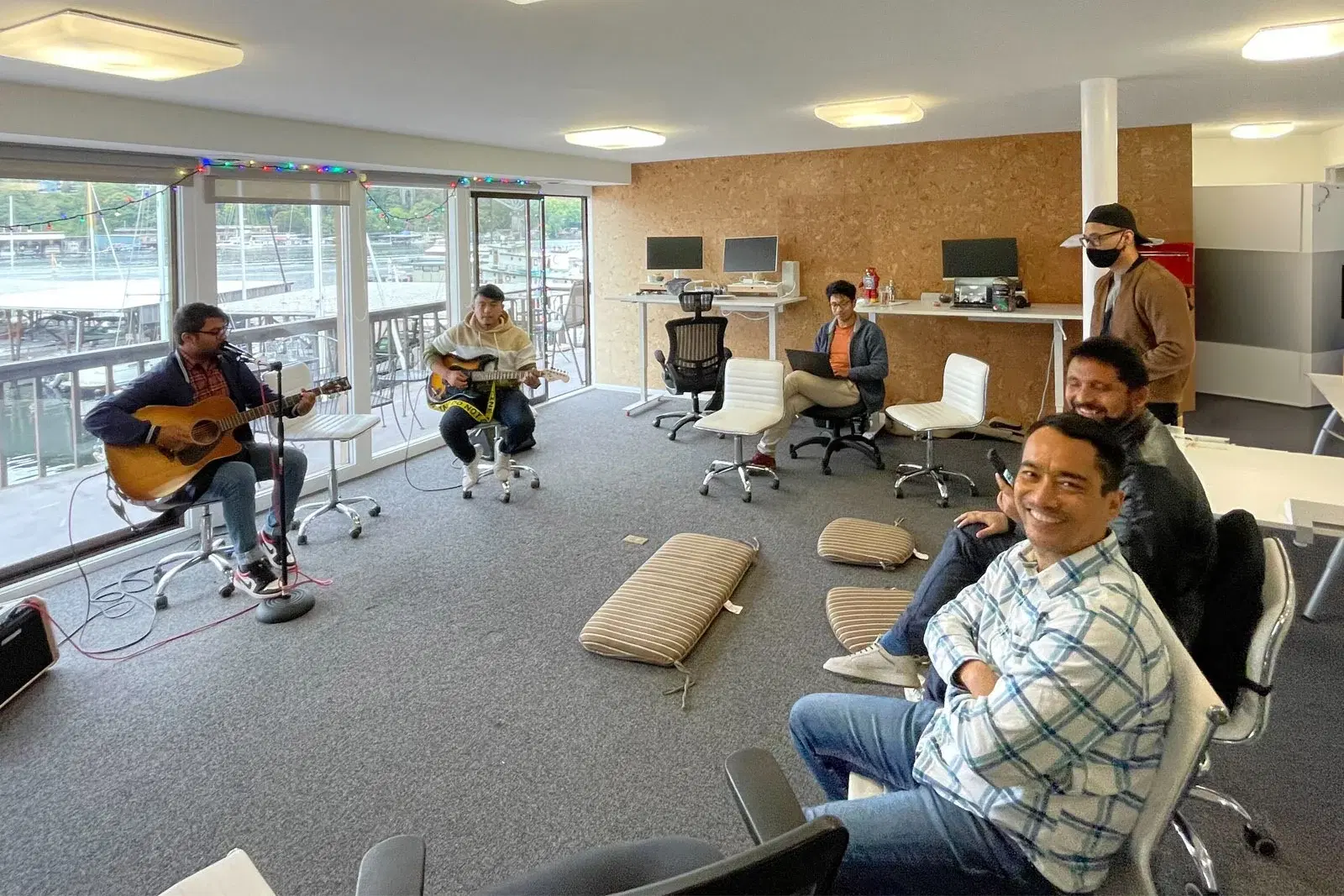 Employees seated in a circular arrangement of chairs, enjoying a musical happy hour while building their bonds.