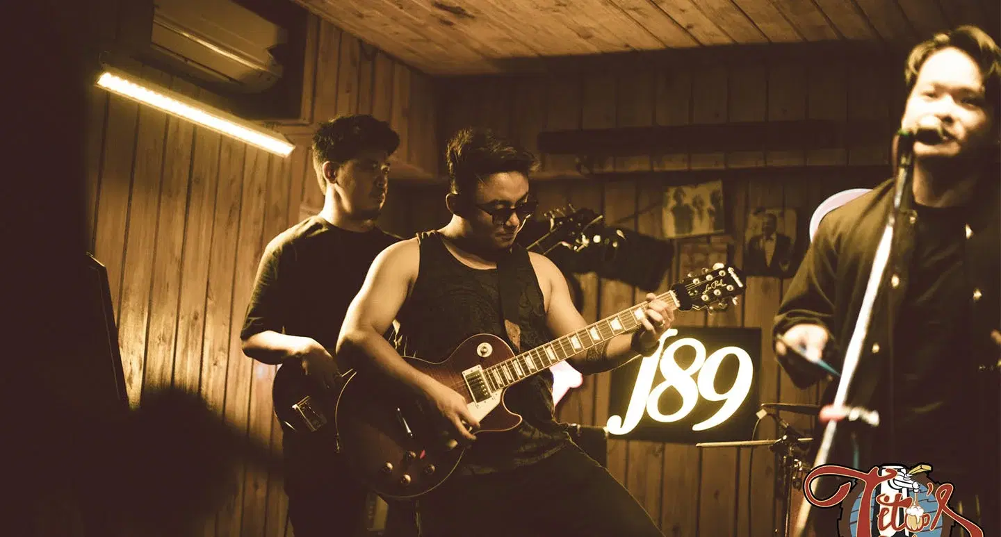 A man playing guitar at a rock night event.